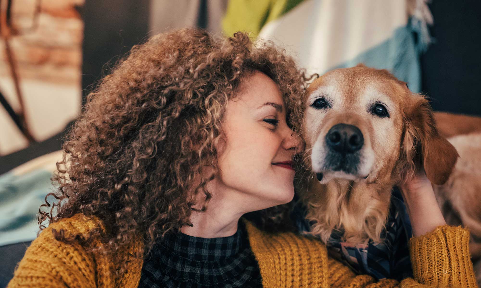 A woman cuddling an older dog